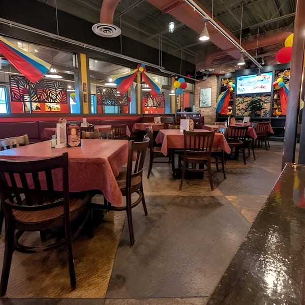 Interior of La Taguara Bar & Grill, featuring dining tables with red tablecloths and Venezuelan flag decorations.